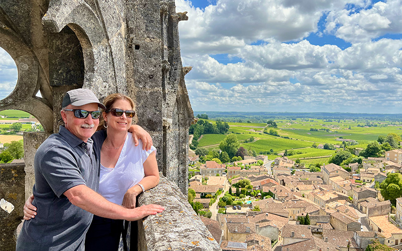 La Chouette Owners, Ben and Michelle looking out at a European village from a high monument